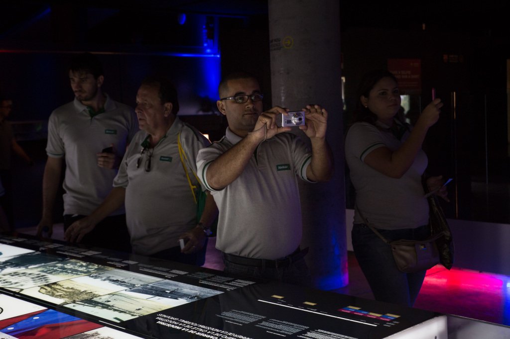 A middle-aged man is taking a photo of the exhibition in a football stadion in barcelona